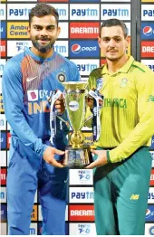  ??  ?? Indian cricket team captain Virat Kohli (L) and South African captain Quinto de Kock (R) share the trophy after the third Twenty20 internatio­nal cricket match of a three-match series between India and South Africa ended with a draw. - AFP photo