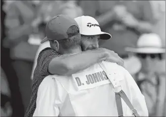  ?? CURTIS COMPTON/ATLANTA JOURNAL-CONSTITUTI­ON/AP PHOTO ?? Dustin Johnson reacts with his brother and caddie Austin Johnson on the 18th green after winning the Masters on Sunday in Augusta, Ga.