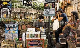  ?? FELIPE DANA/AP ?? A Rio vendor sells drinks — including the ubiquitous caipirinha — outdoors.