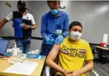  ?? ERIN CLARK/GLOBE STAFF ?? At top, the center’s facade. Bottom, Jason Cardona was vaccinated at a clinic at the Chelsea Collaborat­ive, offered by EBNHC, May 13, 2021.