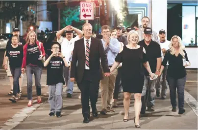  ?? STAFF PHOTO BY C.B. SCHMELTER ?? Steve Lawson, left, and his wife, Connie, lead supporters on a victory march toward the Bradley County Courthouse after he defeated incumbent Sheriff Eric Watson on Tuesday in Cleveland, Tenn.