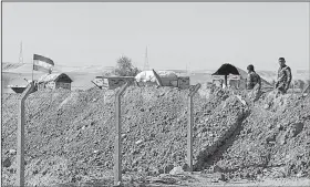  ?? AP/KHALID MOHAMMED ?? Kurdish security forces stand guard Tuesday in defensive positions on the outskirts of Irbil, Iraq.