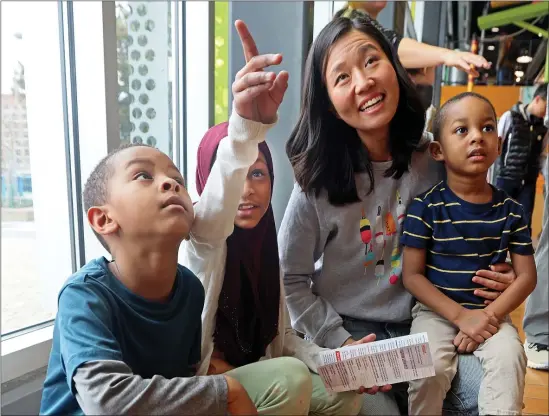  ?? NANCY LANE — BOSTON HERALD ?? Mayor Michelle Wu talks with students Musa Abba-Aji, a 1st grader, his sister Fatima, a 3rd grader and their brother, Abdallah , a preschoole­r, as she visits the Children’s Museum on BPS Sunday.