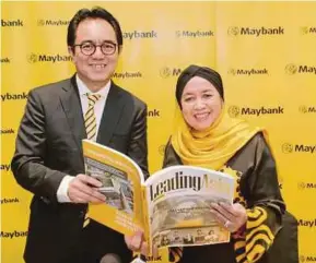  ?? PIC BY AIZUDDIN SAAD ?? Maybank group president and chief executive officer Datuk Abdul Farid Alias and chairman Datuk Mohaiyani Shamsudin with the bank’s annual report at its annual general meeting in Kuala Lumpur yesterday.