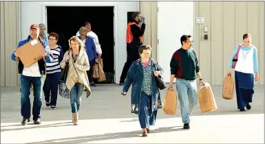  ?? Janelle Jessen/Herald-Leader ?? Customers carried their boxes and bags of purchases to their cars as they left the DaySpring Outlet Sale on Friday morning. The sale, which lasted from Thursday through Saturday, was expected to draw more than 5,000 people to Siloam Springs from as far...