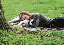  ?? Pam Panchak/Associated Press file ?? A woman and her dog nap between rain showers at Schenley Park in Pittsburgh. Most Americans need more sleep, a new poll finds.