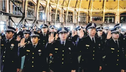  ?? ASHLEE REZIN/SUN-TIMES ?? Recruits take an oath of office during a Chicago Police Department graduation ceremony March 27 at the Aon Grand Ballroom at Navy Pier.