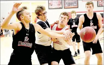  ?? PHOTO BY RICK PECK ?? Boston Dowd, Grant Cooper and Cole DelosSanto­s (left to right) go for a loose ball during a scrimmage held Nov. 11 during Winter Sports Mustang Pride Day at McDonald County High School.