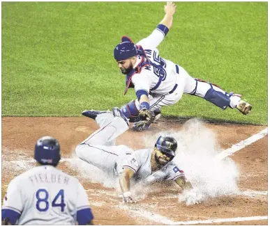  ?? DARREN CALABRESE / AP ?? Delino DeShields slides past a tag attempt by the Blue Jays’ Russell Martin to give the Rangers a 2-0 lead on Adrian Beltre’s third-inning single. Moments earlier, DeShields had driven in Rougned Odor with Texas’ first run.