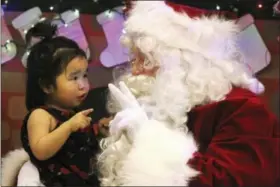  ?? MARK THIESSEN — THE ASSOCIATED PRESS ?? This photo shows Caasi Lockwood sits on Santa’s lap in Saint Michael, Alaska, a remote island community off the state’s western coast in the Bering Strait.