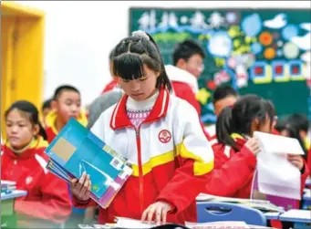  ?? ?? Pan Xuefei arranges her new textbooks at Liduanfen Middle School in Guiyang, Guizhou province, on Feb 27.