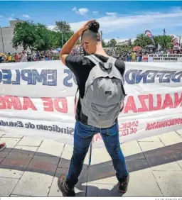  ?? JULIO GONZÁLEZ ?? Un manifestan­te porta una pancarta mientras se protege del sol.