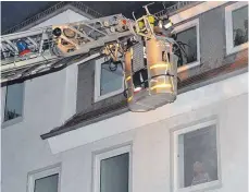  ?? FOTO: KLAUS WEISS ?? „Bewohnerin“Heidi Heil steht verängstig­t am Fenster – doch Rettung naht: Mit Hilfe der Drehleiter wird sie in Sicherheit gebracht.