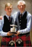  ??  ?? Silverware Connor Sinclair and Pipe Major Richard Parkes MBE, of Field Marshal Montgomery Pipe Band, with the World Pipe Band Championsh­ip trophy