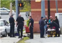  ?? STAFF FILE PHOTO BY ANGELA LEWIS FOSTER ?? Emergency personnel work at the scene of a shooting Friday on Alton Park Boulevard.