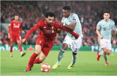  ??  ?? Liverpool’s Mohamed Salah (left) and Bayern Munich’s David Alaba battle for the ball during the Champions League round of 16 first leg match at Anfield in Liverpool, England