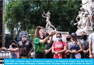  ?? — AFP ?? NEW YORK: A Hawaiian song is performed as members of the Indigenous People’s Day New York City Committee held a Circle of Belonging in Columbus Circle. The group’s long-term goal to remove the statue at Columbus Circle and change Columbus Day to Indigenous People’s Day has been reignited by the current protests against racism.