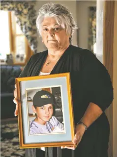  ?? JOSH T. REYNOLDS FOR USA TODAY ?? Ann Marie Crowell holds a photo of her son Brian before the 12-yearold was accidental­ly shot and killed by a friend in 1997.