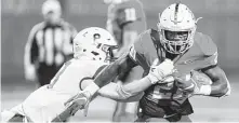  ?? Wilf Thorne / Contributo­r ?? Manvel’s Ladarius Owens, right, breaks the tackle of Barbers Hill’s Branden Heffernan (8) in the first half Thursday night.