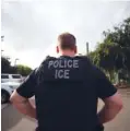  ?? AP PHOTO/GREGORY BULL ?? A U.S. Immigratio­n and Customs Enforcemen­t officer looks on during a July 8 operation in Escondido, Calif.