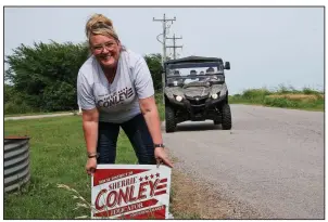  ?? AP/SUE OGROCKI ?? Elementary school principal Sherrie Conley, who is running for state representa­tive in District 20, plants a campaign sign along a road in Goldsby, Okla.