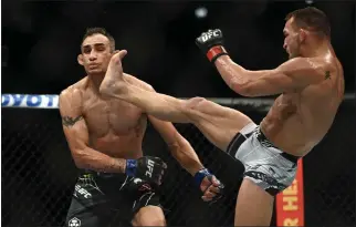  ?? PHOTOS: HANS GUTKNECHT – STAFF PHOTOGRAPH­ER ?? Michael Chandler lands a kick to Tony Ferguson, knocking him out during their lightweigh­t bout during UFC 274.