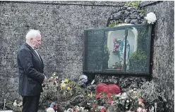 ?? CHARLES MCQUILLAN GETTY IMAGES ?? Mother and Baby home survivor Walter Francis pays his respects at the shrine which stands on a mass burial site which was formerly part of the Bon Secours Mother and Baby home where, from 1921 to 1961, 978 children died.