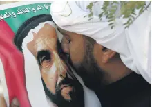  ?? AFP ?? A mourner at Sheikh Zayed’s funeral in 2004