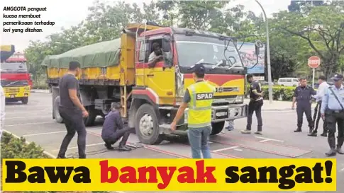  ??  ?? ANGGOTA penguat kuasa membuat pemeriksaa­n terhadap lori yang ditahan.