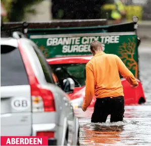  ??  ?? In deep: A man wades through the floodwater in the city’s Ferryhill ABERDEEN