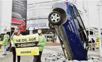  ??  ?? Greenpeace­Aktivisten demonstrie­rten in Frankfurt mit einem im Boden steckenden Auto für eine Verkehrswe­nde hin zur Elektromob­ilität