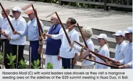  ?? Narendra Modi (C) with world leaders raise shovels as they visit a mangrove seeding area on the sidelines of the G20 summit meeting in Nusa Dua, in Bali. ??