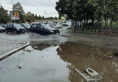  ??  ?? Allarme Via dello Scalo di San Lorenzo trasformat­a in un piccolo lago dalla pioggia che ha riempito una buca e, a sinistra, l’autobus andato a fuoco in via del Tritone il 9 maggio scorso