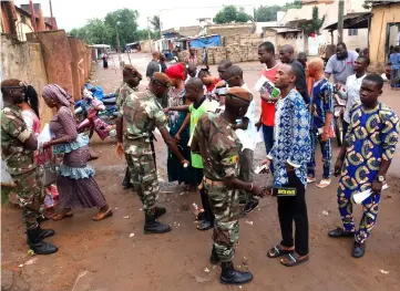  ??  ?? Malian soldiers carry out checks as people wait at a polling station. — Reuters photo