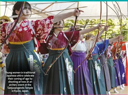  ?? ?? Young women in traditiona­l Japanese attire celebrate their coming of age by shooting arrows at an archery event at the Sanjusange­ndo Temple in Kyoto, Japan.