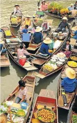  ?? iSTOCK ?? SAILS PITCH: Vendors sit in boats loaded with goods for sale in Amphawa Floating Market