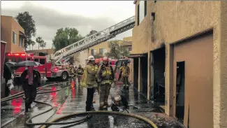  ?? Austin Dave/The Signal ?? Firefighte­rs examine a charred apartment building at Park Sierra Apartments in Canyon Country last week. The family living there is now homeless and behind on rent, according to the mother of the family.