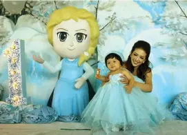  ?? NURUL KOMARIYAH/JAWA POS ?? BLUE ICE: Cheverly Graciella Susanto bersama sang mama, Anita Valen, di atas panggung utama yang didesain seperti istana tokoh film Frozen, Elsa dan Anna.