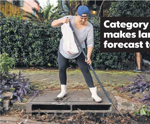  ?? BRYAN TARNOWSKI, AFP/ GETTY IMAGES ?? Johnice Katz works to clear the storm drain in front of her New Orleans home Saturday in preparatio­n for Hurricane Nate.