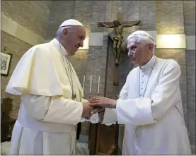  ?? L’OSSERVATOR­E ROMANO — POOL PHOTO VIA AP FILE ?? Pope Francis, left, and Pope Benedict XVI meet each other on the occasion of the elevation of five new cardinals at the Vatican on June 28, 2017.