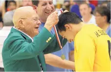  ?? GREG SORBER/JOURNAL FILE ?? Legendary ex-Albuquerqu­e High hoops coach Jim Hulsman, shown placing a medal on St. Pius’ Micah Sanchez before the North-South 4A/5A all-star game in 2013, has many fond memories of brother Tom.