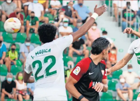  ??  ?? En Nesyri remata ante Diego González en la acción que supuso el gol del empate del Sevilla. El Elche reclamó falta por un codazo a Pere Milla.