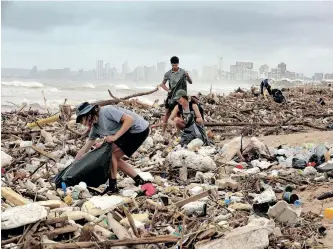  ?? | SHELLEY KJONSTAD ?? AS MORE dark clouds loom over Durban, (from front) Gabriel Attwood, Kelly Gasson, Luke Lerothooi and Gillian Attwood join clean-up operations on the beachfront. African News Agency (ANA)