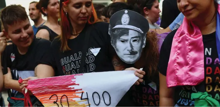  ?? ?? ►Un● persona lleva una máscara que representa la mitad de la cara de Javier Milei y la mitad del rostro del exdictador argentino Jorge Rafael Videla durante una manifestac­ión.