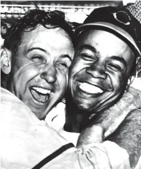  ?? CLEVELAND PLAIN DEALER ?? Cleveland Indians pitcher Steve Gromek and center fielder Larry Doby embrace after Doby’s home run gave the Indians a 2-1 win in Game 4 of the 1948 World Series. This was the first widely-publicized photo of black and white baseball players embracing...