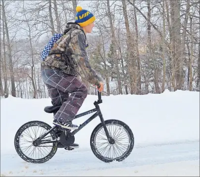  ?? DAVID JALA/CAPE BRETON POST ?? A heavy snowfall of more than 20 cm may have left many Cape Breton residents grumbling about having to dig out on the first day of spring but others like Avery Skeete embraced the weather. Above, the Sydney resident makes his way along a snow-covered...