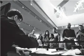  ??  ?? People observe how Chinese calligraph­y is done at the Acropolis Museum in Athens. Two artists from Shanghai Museum initiated visitors to the Acropolis Museum in the Greek capital into the traditiona­l Chinese arts of calligraph­y and painting. — Xinhua