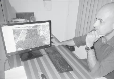  ??  ?? Pedro Correa, director of the environmen­t in the Paranaita city government, looks at a photo of the city surrounded by forests, on his computer screen. Originally from the southern state of São Paulo, he worked for a few months on the constructi­on of...