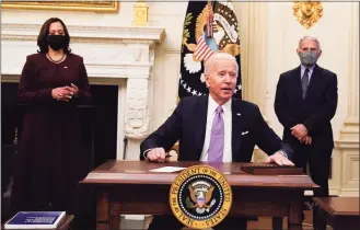  ?? Alex Brandon / Associated Press ?? President Joe Biden reacts to a reporter’s question after signing executive orders in the State Dinning Room of the White House, in Washington. Vice President Kamala Harris and Dr. Anthony Fauci, director of the National Institute of Allergy and Infectious Diseases, look on.