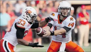  ?? — THE CANADIAN PRESS FILES ?? B.C.Lions quarterbac­k Travis Lulay hands off the ball to running back Andrew Harris Saturday in Ottawa.